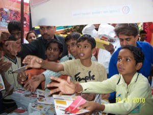 Children in Delhi reach for educational materials